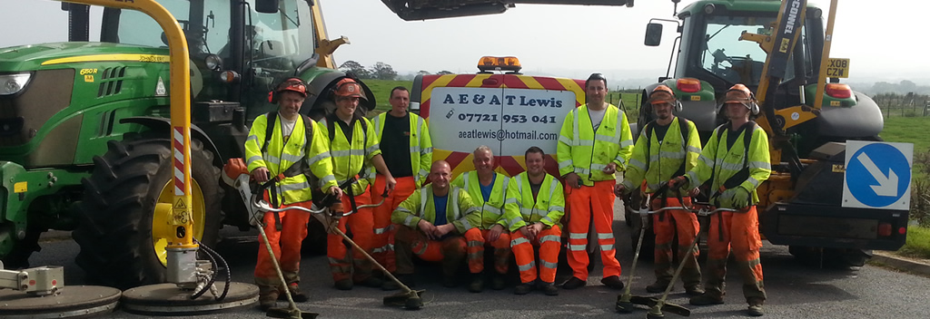 AE & AT Lewis staff holding petrol strimmers in front of tractors
